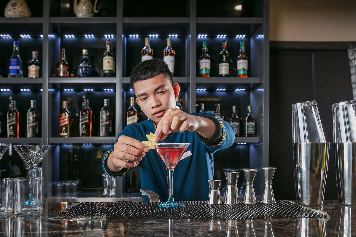 Bartender preparing a cocktail at the bar of DeLaSol Phat Linh Hotel Sapa