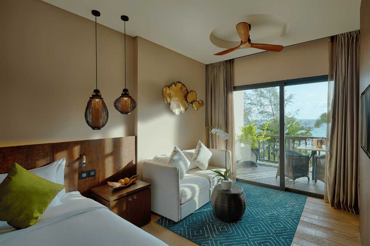 Room at Nam Nghi Coral Peninsula Phu Quoc Resort with sofa seating area and balcony