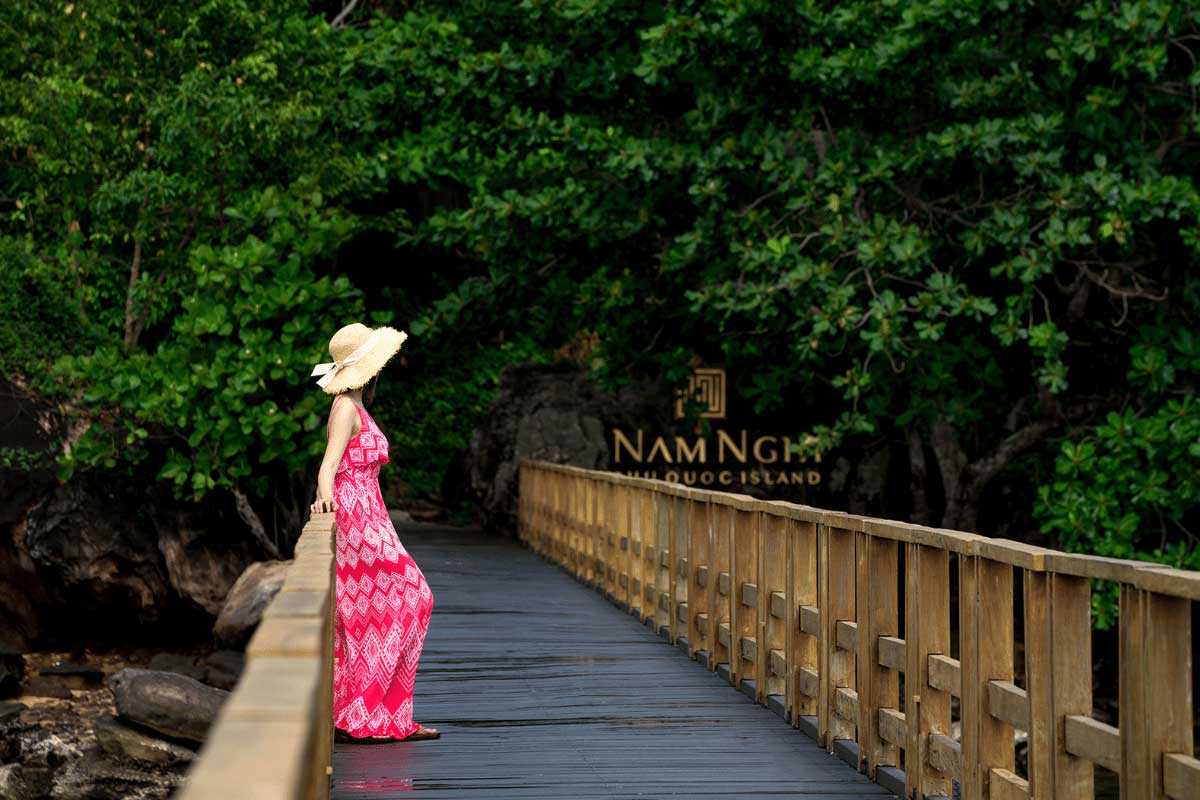 Wooden boardwalk through tropical nature at Nam Nghi Coral Peninsula Phu Quoc Resort