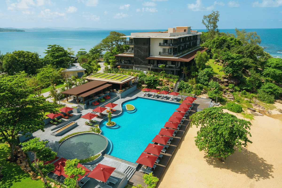 Swimming pool area at Nam Nghi Coral Peninsula Phu Quoc Resort surrounded by tropical greenery and beach