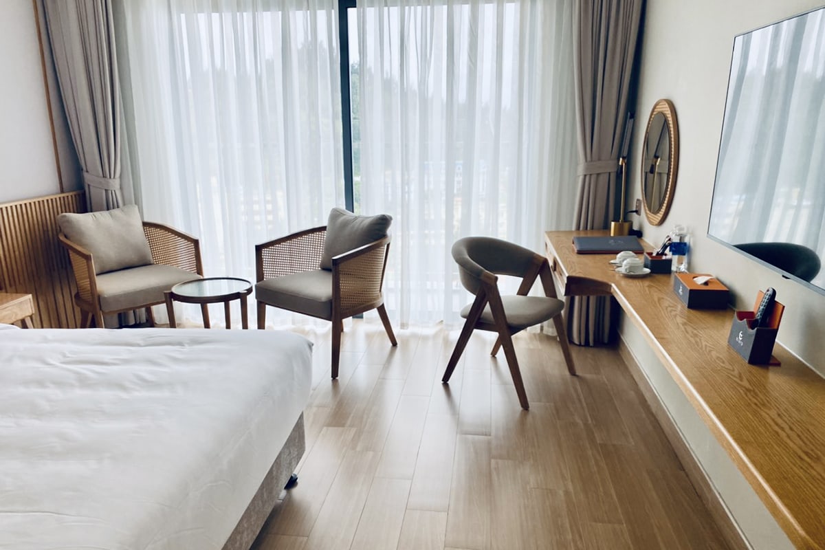 Double room at Seabird Hotel Thien Cam with seating area balcony window and modern interior